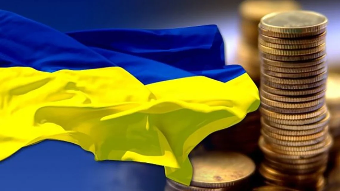 Прапор України та монети як символ зростання економіки за прогнозом МВФ