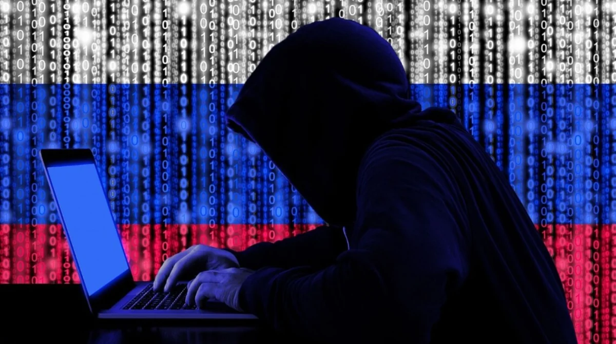 Російський хакер у капюшоні атакує МЗС Британії з ноутбука на тлі прапора РФ