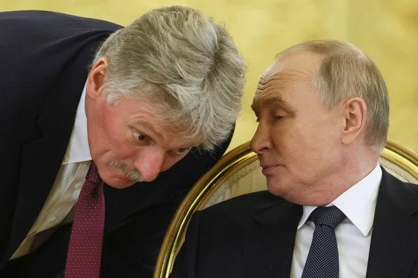 Дмитро Пєсков нахилився і шепоче Володимиру Путіну на зустрічі