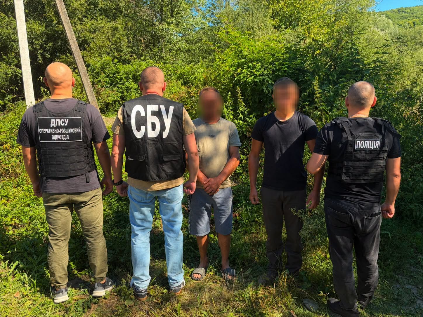 Силовики ДПСУ, СБУ і поліції з двома затриманими чоловіками серед дерев
