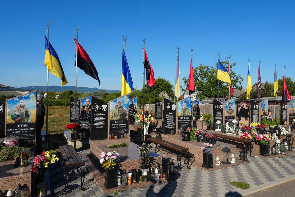 Меморіал полеглих захисників з українськими прапорами та квітами в Тячеві