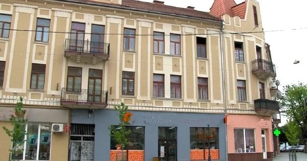 Історичний будинок центру Ужгорода з жовто-білим фасадом та червоною покрівлею