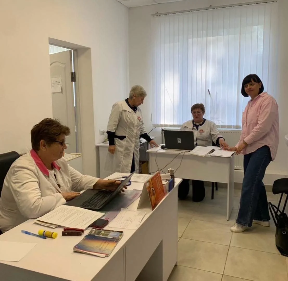 Спеціалісти в білих халатах за столами з ноутбуками в кабінеті